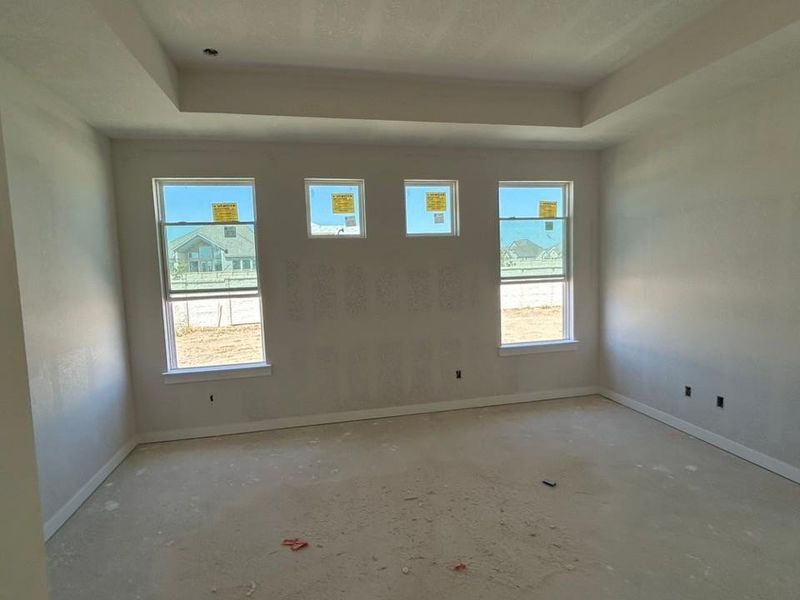 Spare room featuring baseboards and a raised ceiling