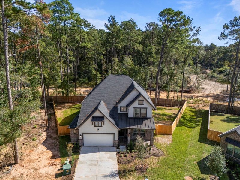 Front exterior of a new home in The Woodlands Hills, Willis, TX, highlighting curb appeal (Image 1).