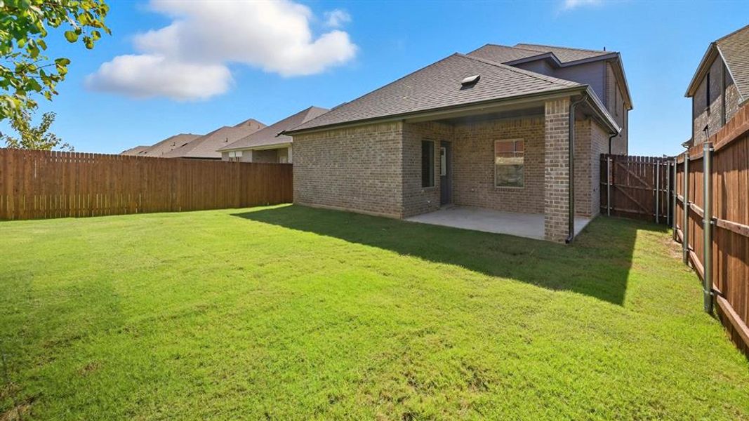 Rear view of property with brick siding, a patio area, roof with shingles, and a fenced backyard Rear view of property with brick siding, a patio area, roof with shingles, and a fenced backyard