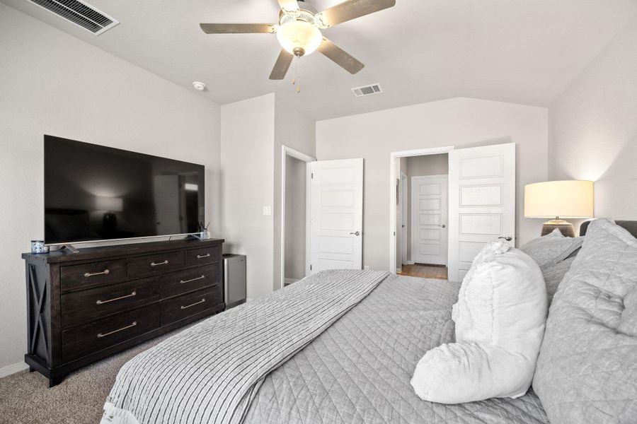 Bedroom with a ceiling fan, light colored carpet, and lofted ceiling Bedroom with a ceiling fan, light colored carpet, and lofted ceiling