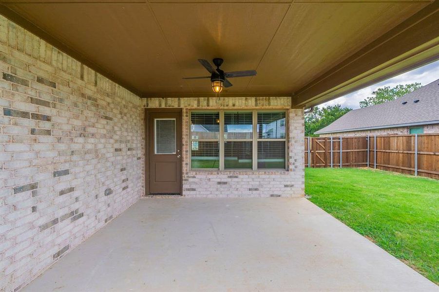 Covered brick patio, lighted farmhouse ceiling fan , stained privacy fence