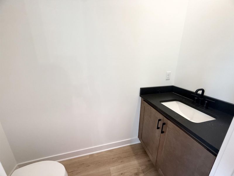 Half bath with vanity and wood finished floors