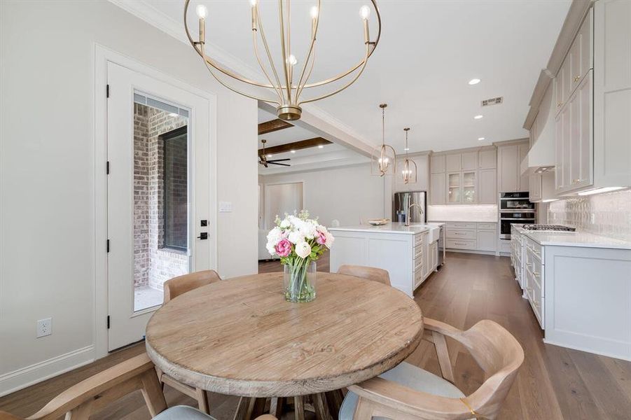 Dining room featuring a chandelier, wood finished floors, beamed ceiling, recessed lighting, and ceiling fan Dining room featuring a chandelier, wood finished floors, beamed ceiling, recessed lighting, and ceiling fan