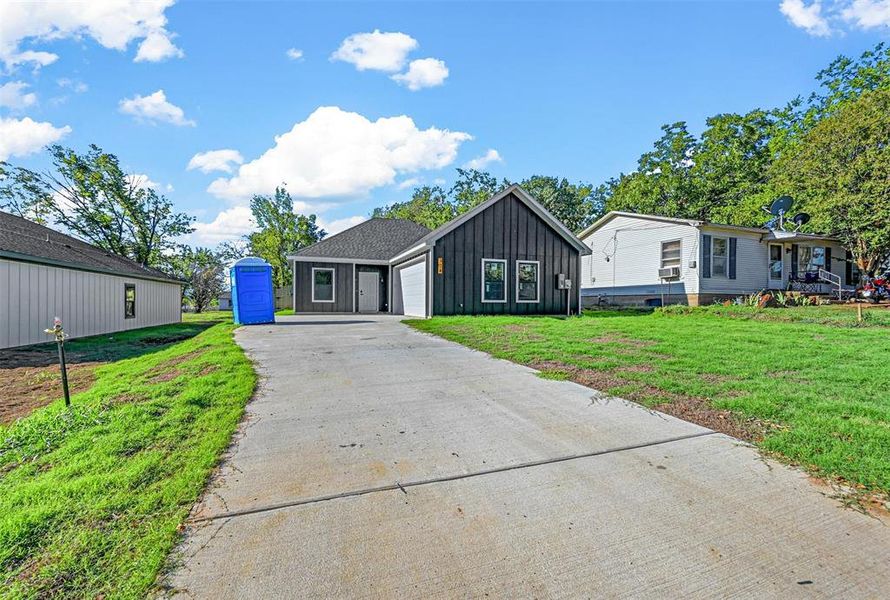 View of front of home with a front lawn and a garage