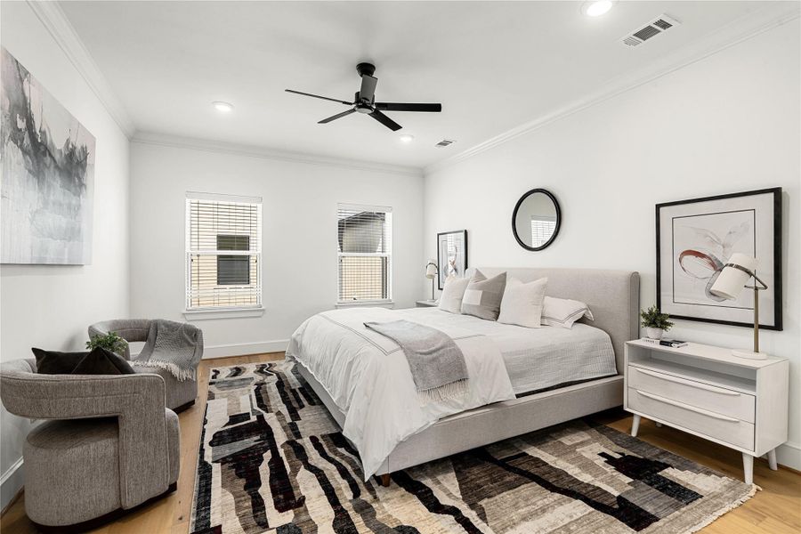 Primary bedroom on the third floor featuring hardwood floors, ample natural light, and a serene atmosphere - perfect for relaxing at the end of the day.