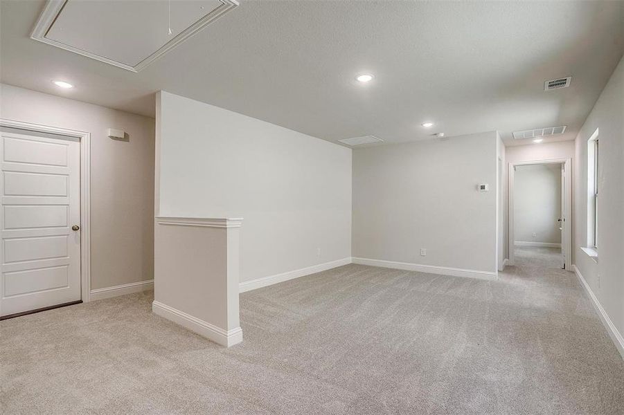 Unfurnished room featuring attic access, light colored carpet, and recessed lighting