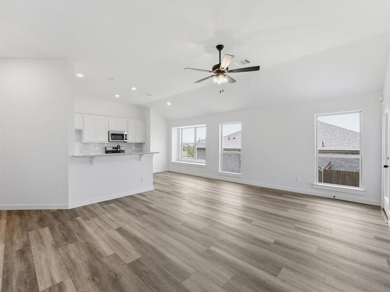 Open concept living area featuring wood-finish flooring, recessed lighting, and a ceiling fan Open concept living area featuring wood-finish flooring, recessed lighting, and a ceiling fan