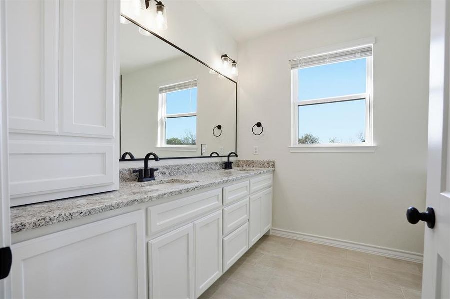 Bathroom with double vanity and baseboards Bathroom with double vanity and baseboards