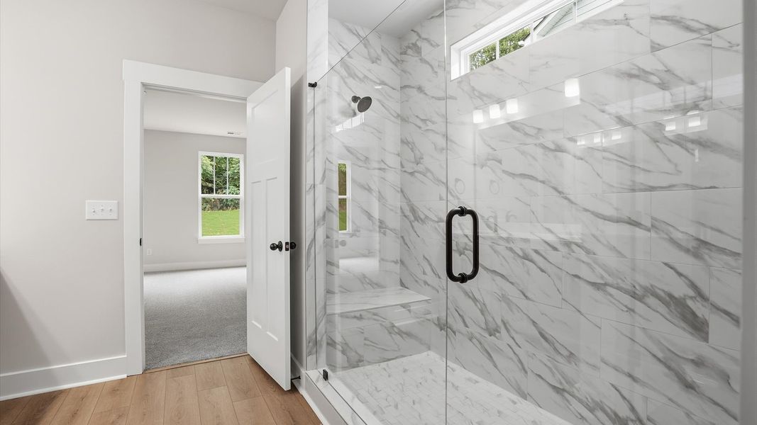 Exceptional en-suite with natural light and a glass-enclosed walk-in shower for superior everyday comfort