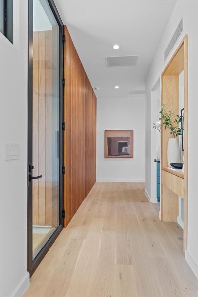 Looking left past the front entry door toward the downstairs bedroom/office and laundry room