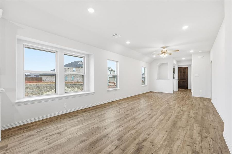 Unfurnished living room featuring healthy amount of natural light, light wood-type flooring, a ceiling fan, and recessed lighting