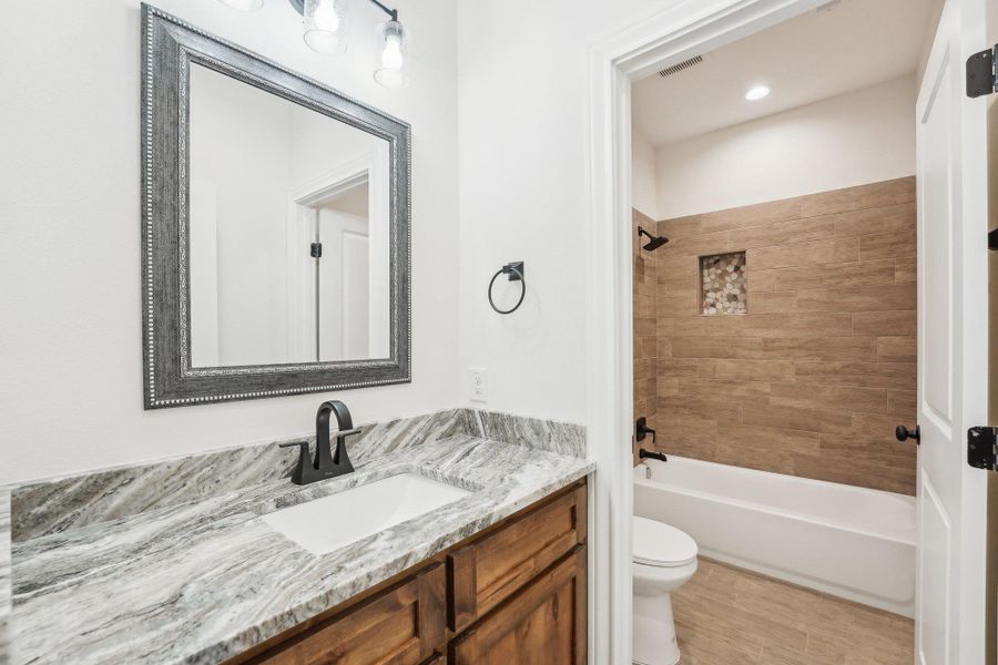 Full bathroom featuring visible vents, toilet, shower / bathing tub combination, and vanity Full bathroom featuring visible vents, toilet, shower / bathing tub combination, and vanity