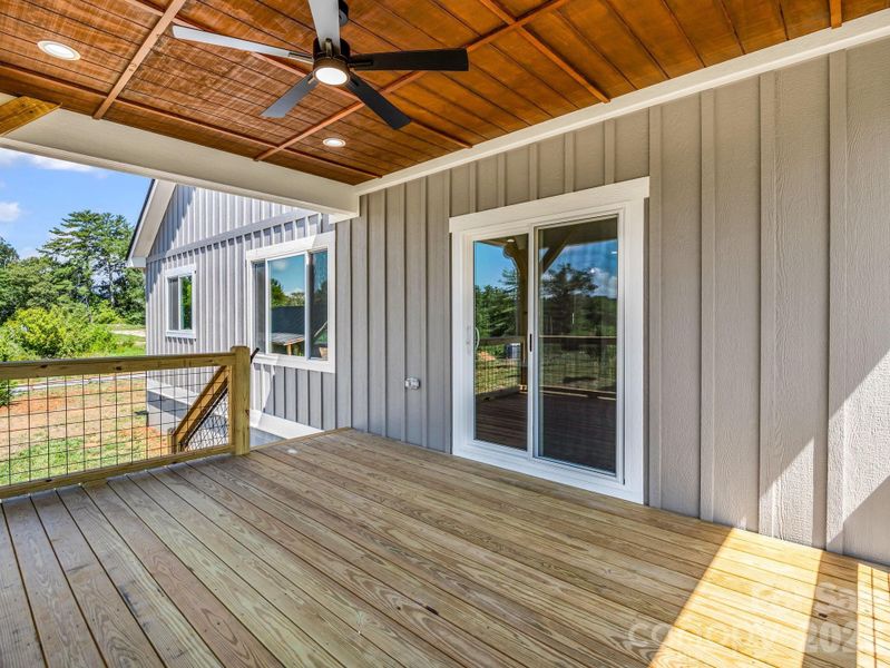 Covered rear porch with a fan and sliding doors leading to the main living spaces Covered rear porch with a fan and sliding doors leading to the main living spaces