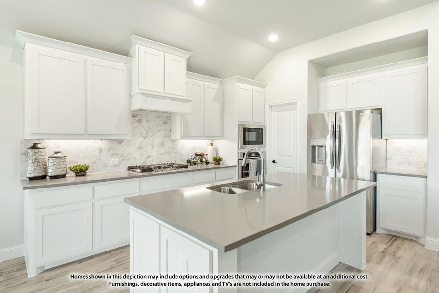 Kitchen with white cabinets, gray quartz island, marble backsplash, and stainless steel appliances