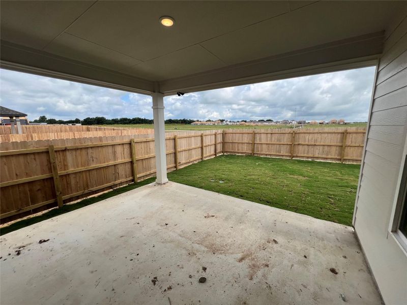 A spacious covered patio overlooks a generous private yard, fully fenced for ultimate privacy.