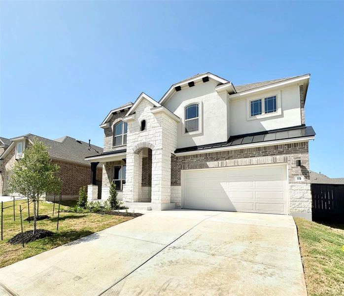 View of front of home with stone siding, concrete driveway, a garage, and stucco siding View of front of home with stone siding, concrete driveway, a garage, and stucco siding