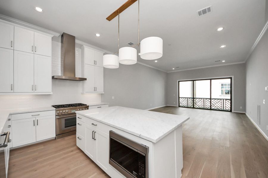 Alternate view of the kitchen showcasing custom cabinetry, premium finishes, and open-concept design. Alternate view of the kitchen showcasing custom cabinetry, premium finishes, and open-concept design.