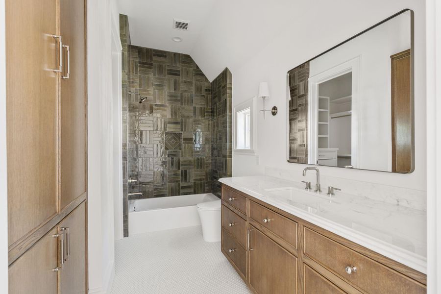One of three beautifully adorned ensuite secondary baths with designer tiles and ample storage. One of three beautifully adorned ensuite secondary baths with designer tiles and ample storage.