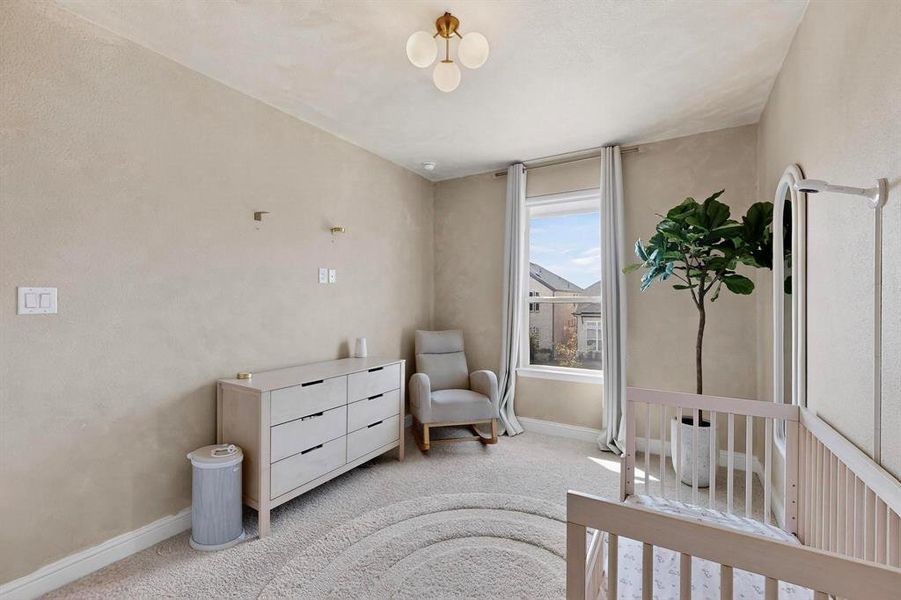 Bedroom featuring a crib and carpet floors Bedroom featuring a crib and carpet floors