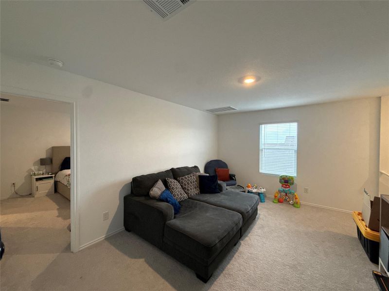 Carpeted bonus room with neutral walls, recessed lighting, and a single window with blinds