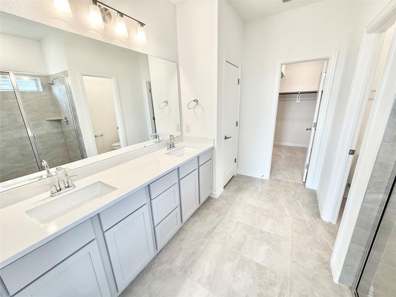 Bathroom with a stall shower, double vanity, and a walk in closet Bathroom with a stall shower, double vanity, and a walk in closet