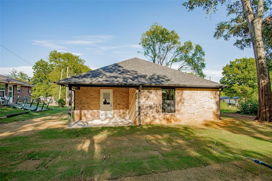 View of front of home with brick siding, roof with shingles, and a front yard View of front of home with brick siding, roof with shingles, and a front yard