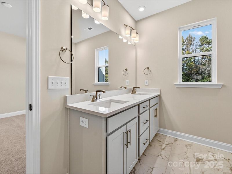 Primary Bath with Dual Vanity and Tree-Lined Views.