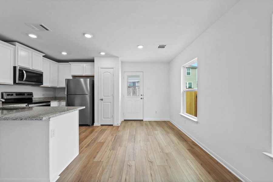 Gleaming wood floors anchor a bright kitchen and casual dining area.