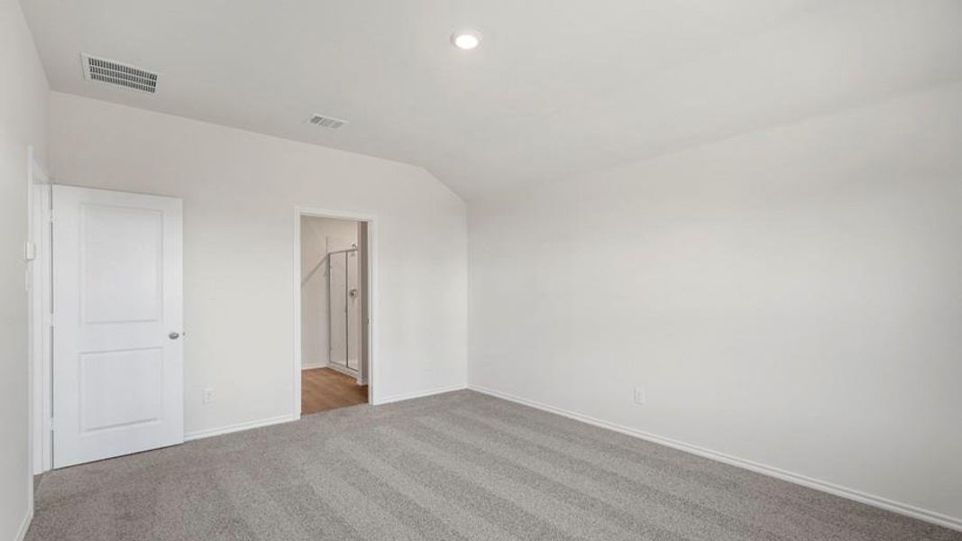 Carpeted room featuring white walls, a vaulted ceiling, and recessed lighting