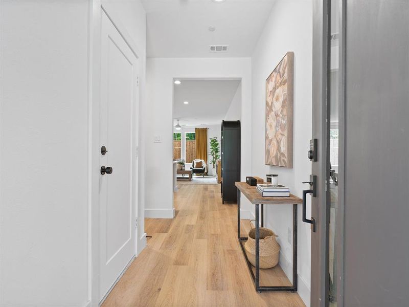 Corridor with light wood-style floors, baseboards, recessed lighting, and visible vents Corridor with light wood-style floors, baseboards, recessed lighting, and visible vents