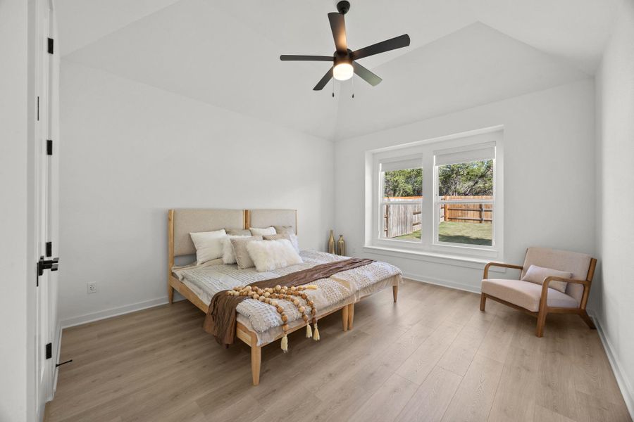 Bedroom featuring light wood finished floors, a ceiling fan, and lofted ceiling