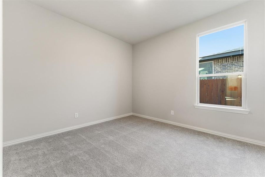 Empty room featuring baseboards and light carpet