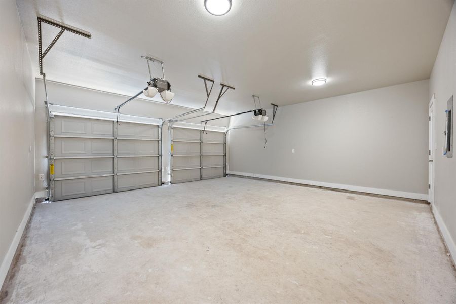 Garage with a garage door opener and baseboards Garage with a garage door opener and baseboards