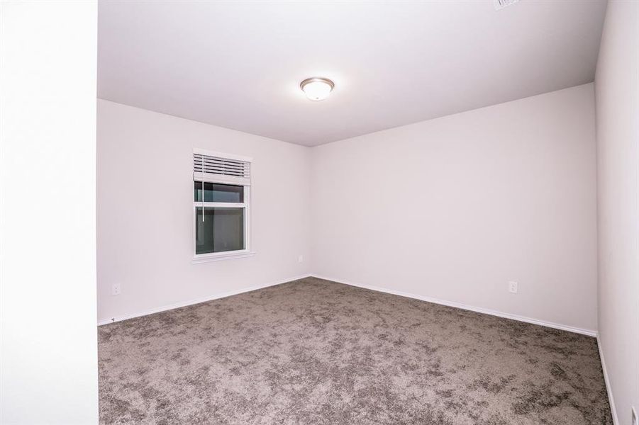 Unfurnished room featuring dark colored carpet