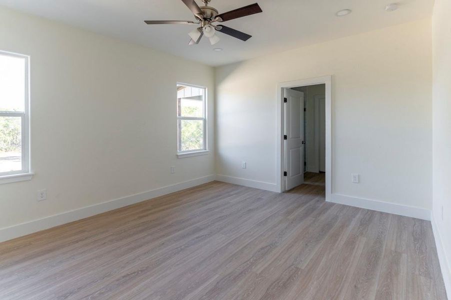 Spare room featuring light wood-style floors, ceiling fan, and recessed lighting