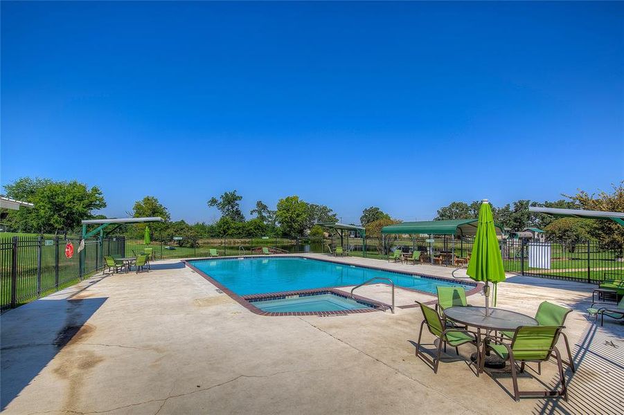 Community pool featuring a community hot tub and a patio area
