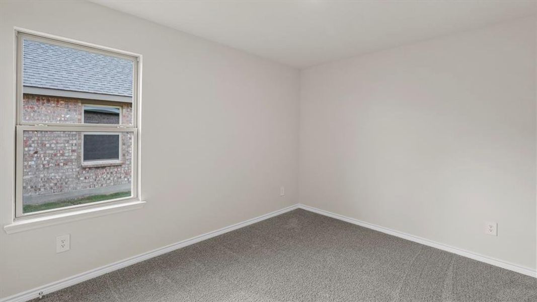 Neutral wall tones, gray carpet flooring, white trim, and a white-framed window