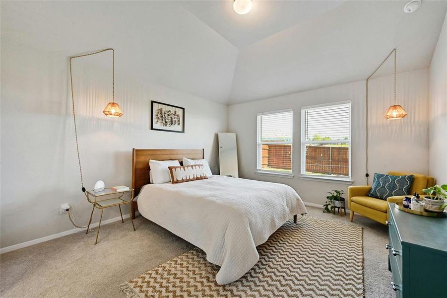 Large primary bedroom with a view of the backyard.