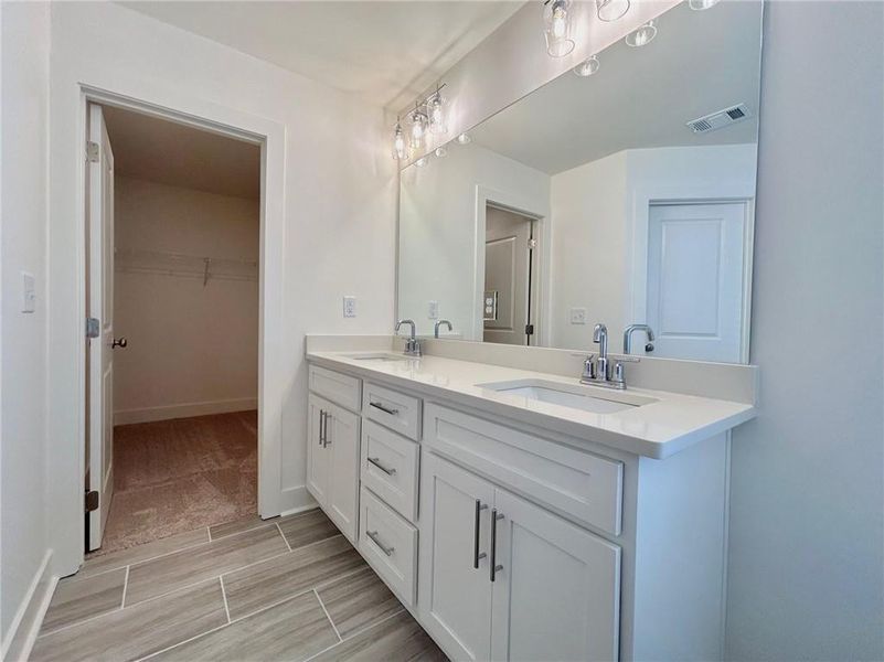 Bathroom with double vanity and tile flooring