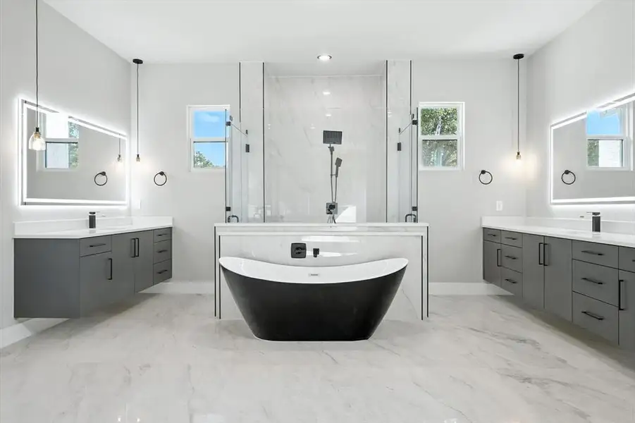 Bathroom with plenty of natural light, a marble finish shower, a soaking tub, and recessed lighting Bathroom with plenty of natural light, a marble finish shower, a soaking tub, and recessed lighting