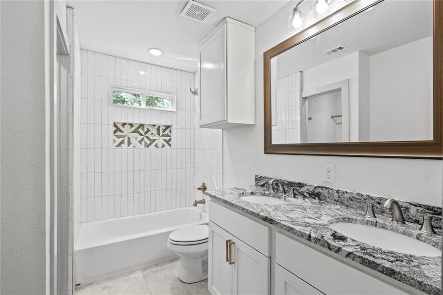 Full bathroom featuring shower / bathtub combination, double vanity, light tile patterned floors, and recessed lighting