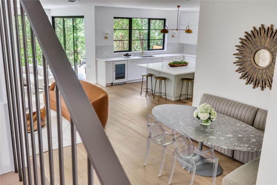 Open-concept living area featuring light wood-finish flooring, a contemporary kitchen, and an integrated dining space