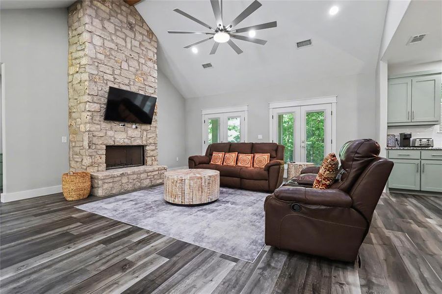 Living space featuring a stone-clad fireplace and wood-finish flooring
