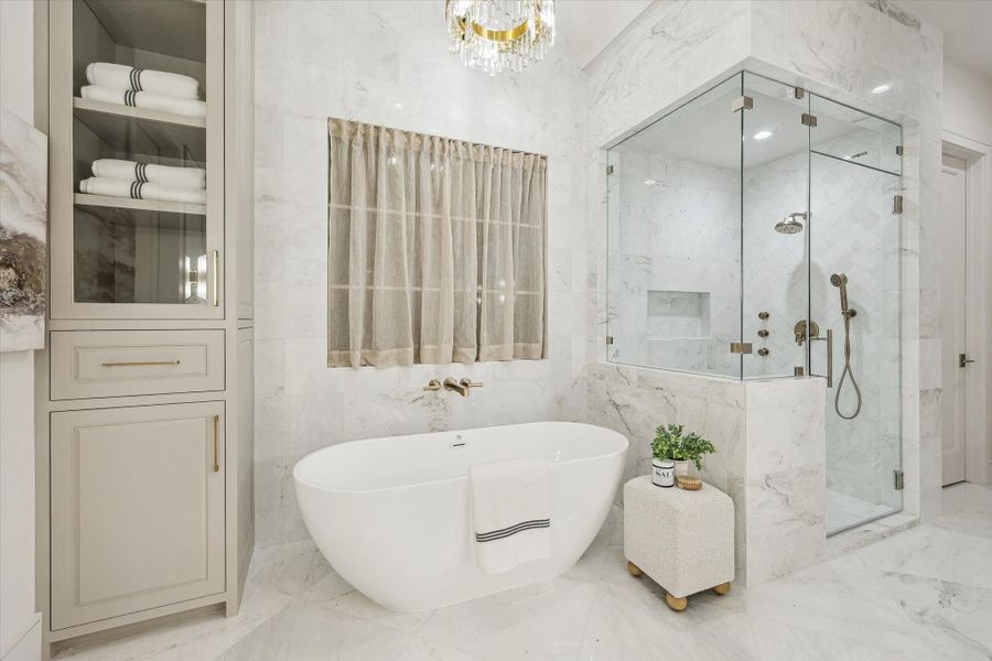 The freestanding soaking tub with wall-mounted hardware and spacious shower. Polished gold fixtures maintain the luxurious feel, coupled with the marble detailing throughout. A handheld sprayer and trio of body jets create a spa-like feel from your very own home.