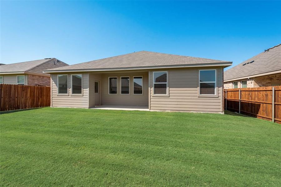 Rear view of property with a lawn and a patio