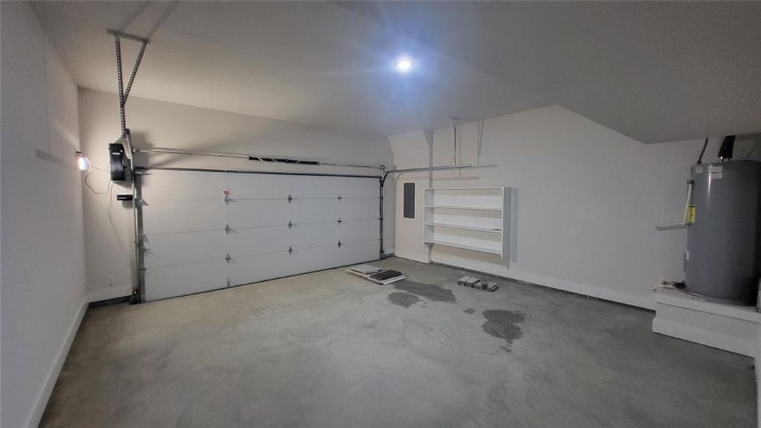Garage featuring water heater, electric panel, and baseboards