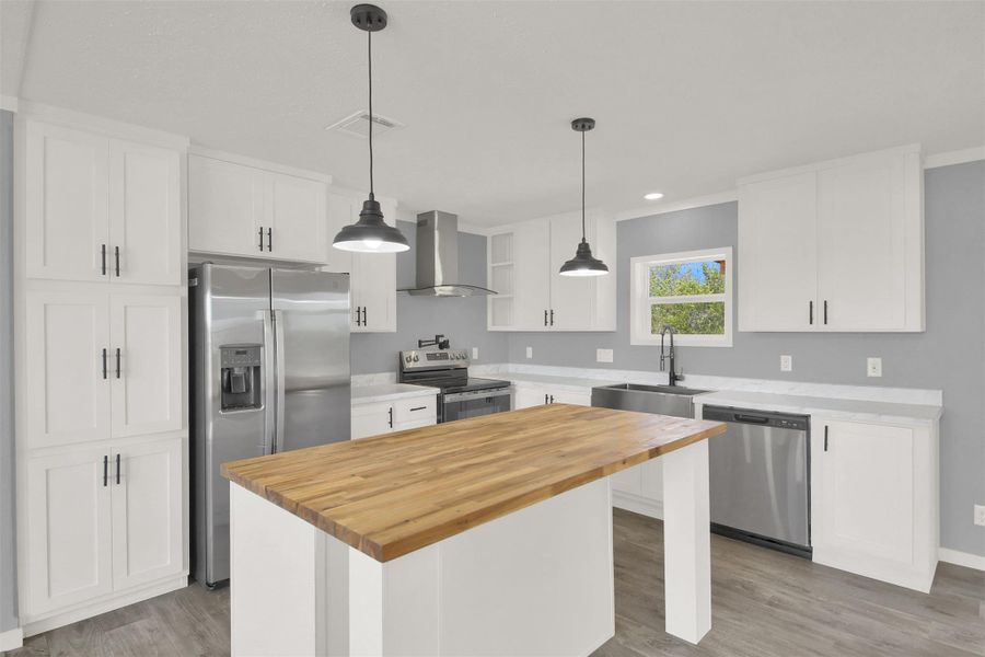 Clean lines and a spacious wooden island highlight this modern cooking space.