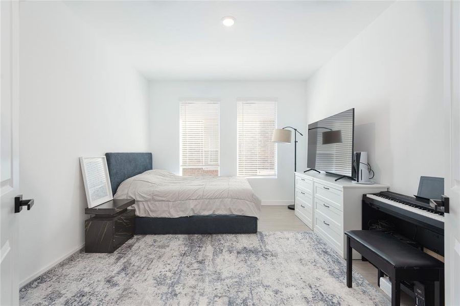 Bedroom with baseboards and light wood-type flooring Bedroom with baseboards and light wood-type flooring