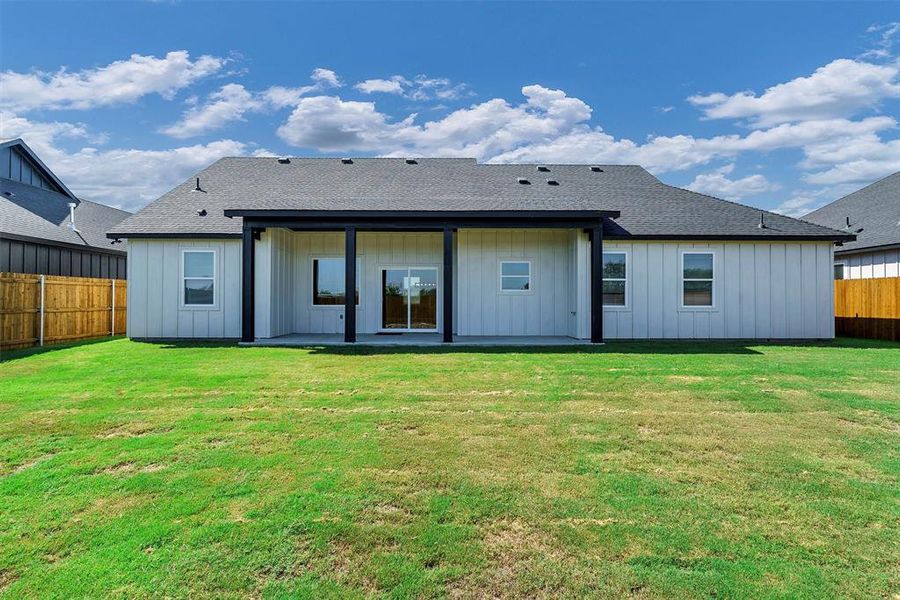 Back of house featuring a lawn and a patio