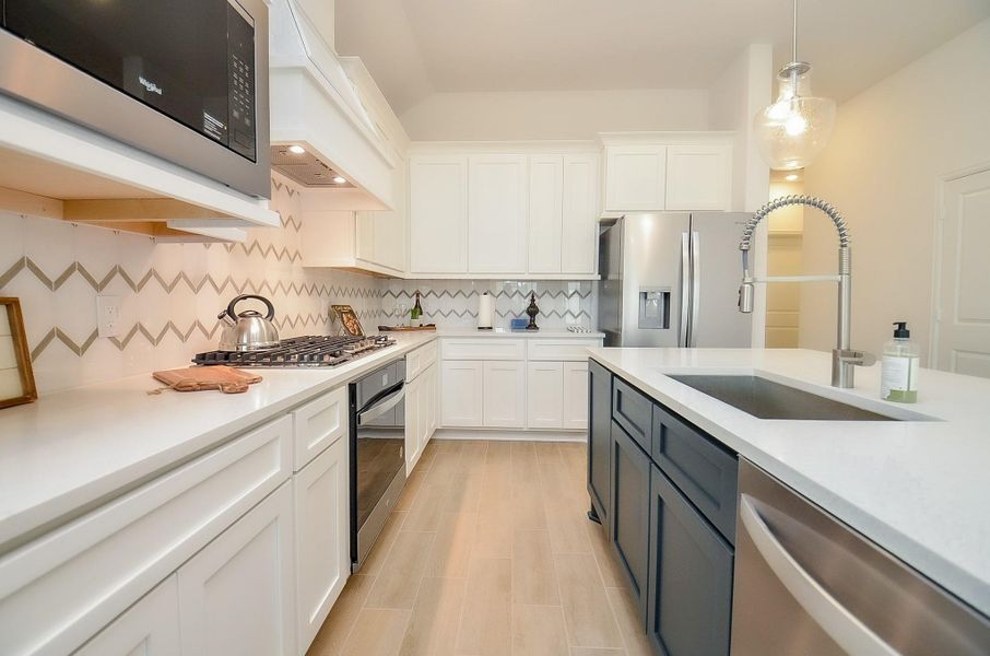 Sleek stainless steel appliances including fridge that stays with the home.